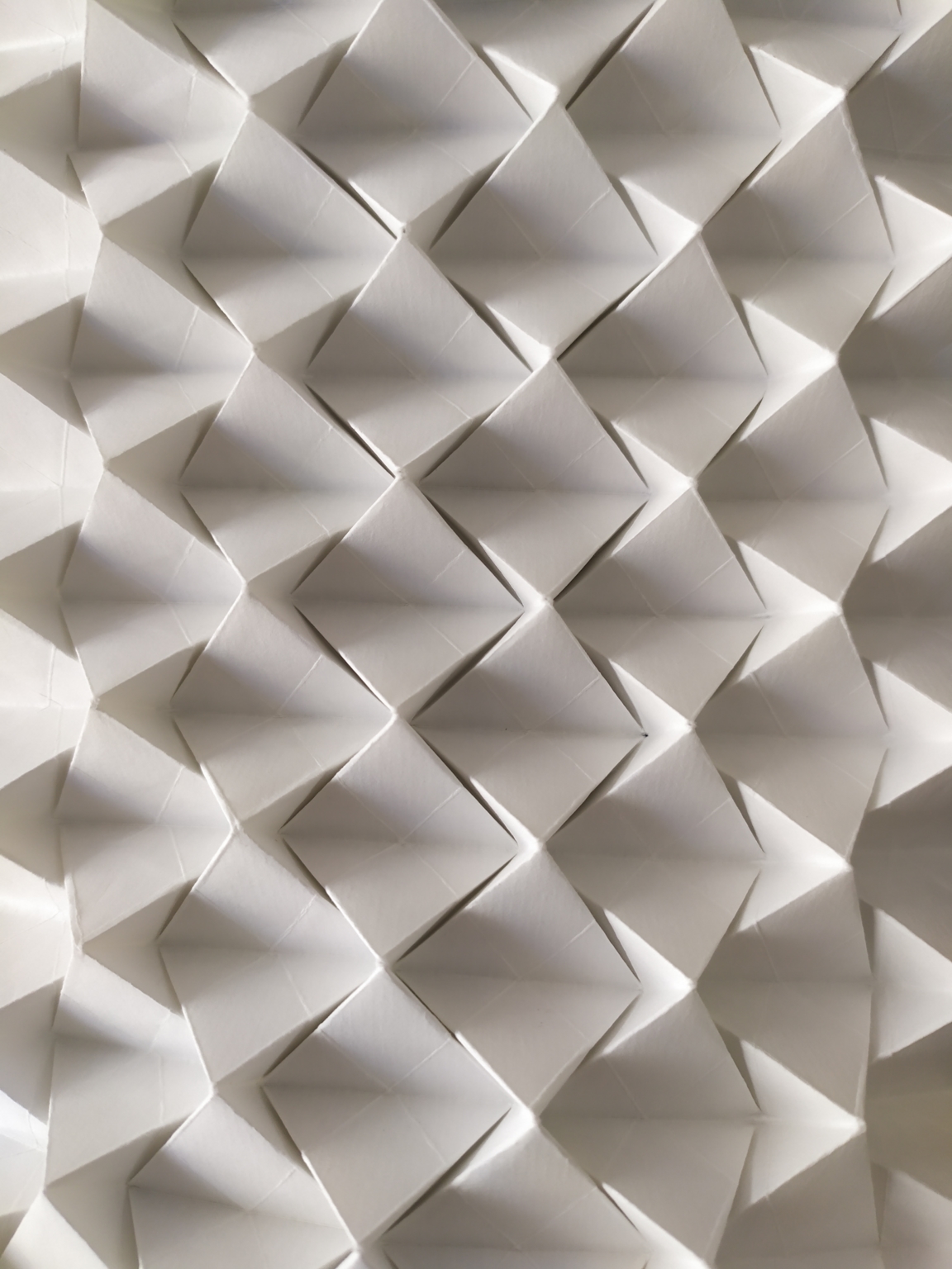 Estructura plegada de módulos piramidales en papel blanco – Dario Zeruto