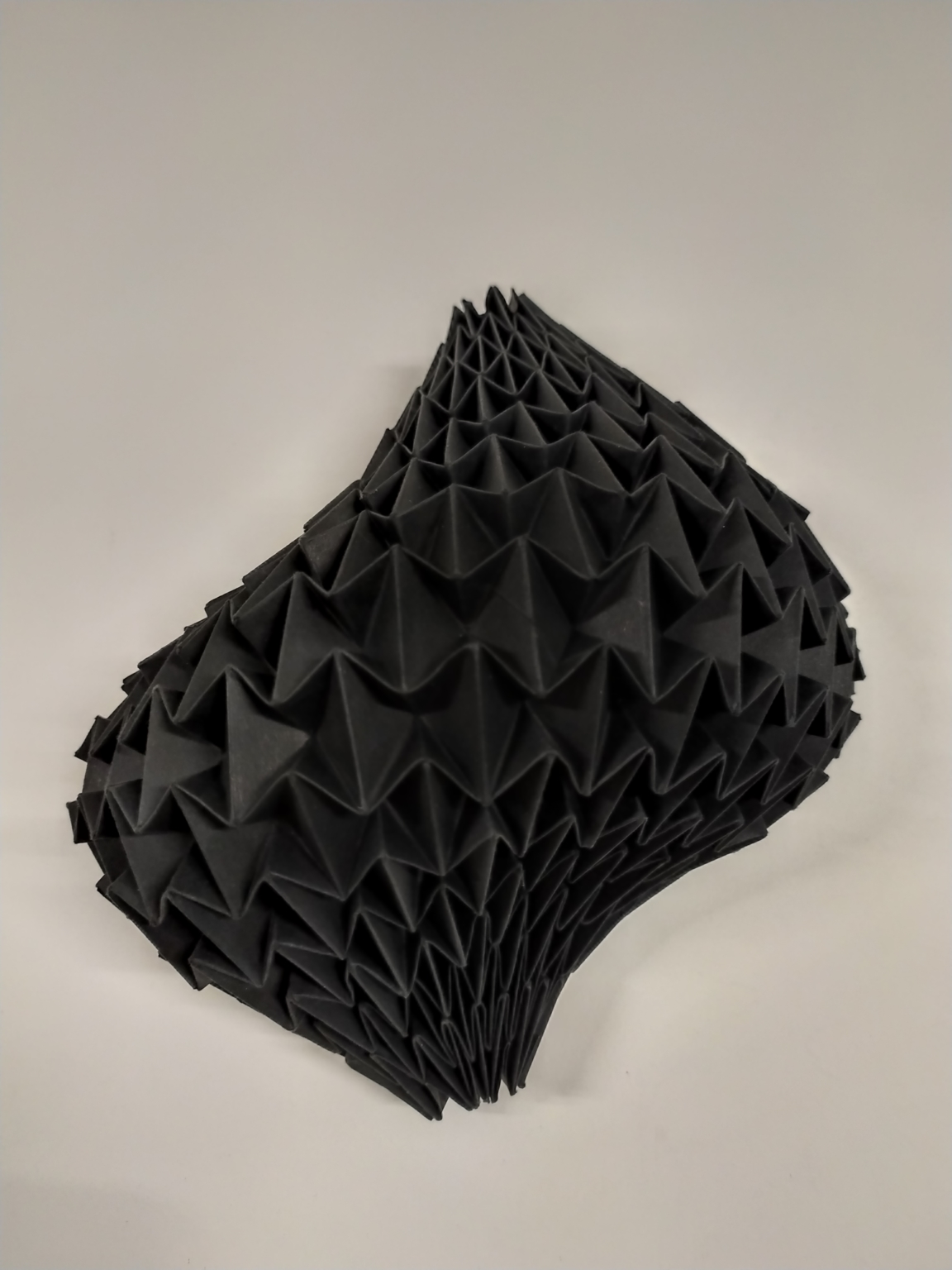 Estructura plegada de papel negro que se curva en el espacio – Dario Zeruto
